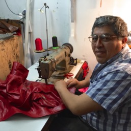 The beautiful red leather jacket being sewn/
		    