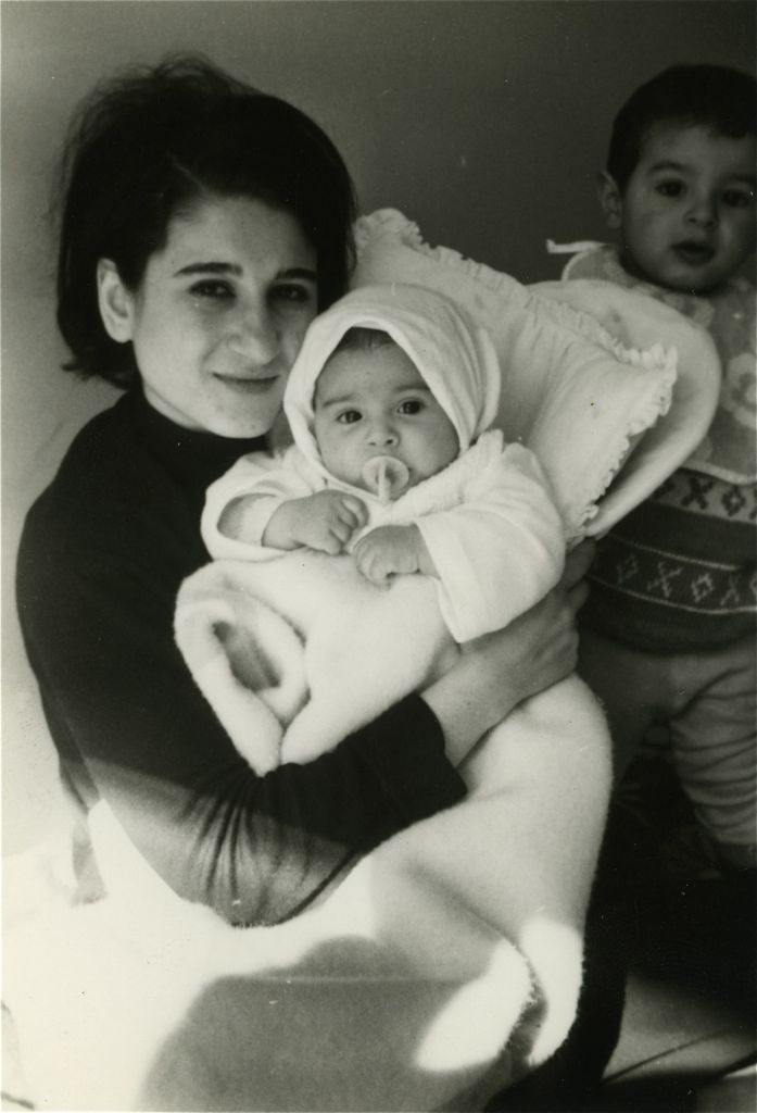 Aunt Karman holding Assana with Koohy looming in the back/